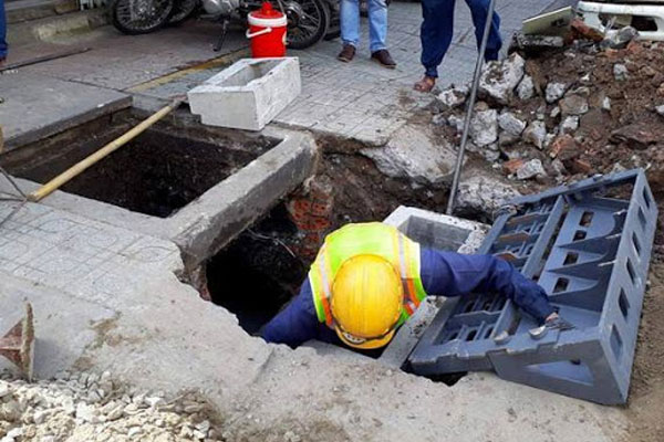 nhân viên đang thông tắc cống tại khu vực Hà Đông