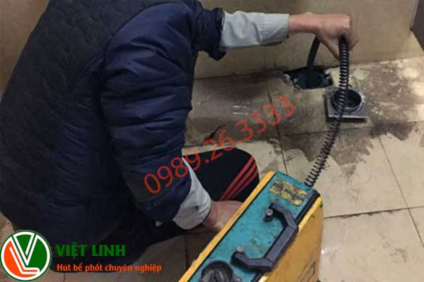 Nhân viên đang thông tắc cống tại Long Biên